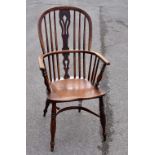 A 19th century elm seated Windsor elbow chair with pierced splat back on turned supports united by a