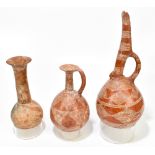 Three Native American red glazed vessels with sgraffito decoration, height 28cm, 18cm and 18.5cm.