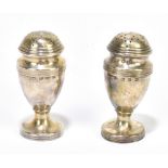 THOMAS HAYES; a pair of Victorian hallmarked silver pounce pots with cast linear decoration,