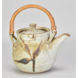 A stoneware teapot with cane handle covered in grey glaze with iron decoration, painted AM mark,