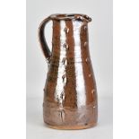 JIM MALONE (born 1946); a stoneware pitcher covered in tenmoku breaking to kaki glaze with impressed