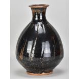 JIM MALONE (born 1946); a large bulbous faceted stoneware bottle covered in tenmoku breaking to kaki