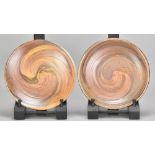 MICKI SCHLOESSINGK (born 1949); a pair of salt glazed plates partially covered in shino glaze,