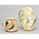 MAUREEN MINCHIN (born 1954); a slip decorated earthenware jug depicting fish, height 17cm, and a mug