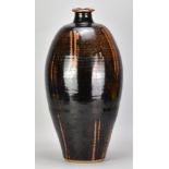 PHIL ROGERS (1951-2020); a very large stoneware bottle covered in tenmoku breaking to kaki glaze