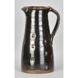 JIM MALONE (born 1946); a large stoneware pitcher covered in tenmoku breaking to kaki glaze with