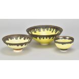 PETER WILLS (born 1955); a porcelain bowl covered in bright yellow glaze with bronze running from
