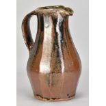 JIM MALONE (born 1946); a fluted stoneware pitcher covered in tenmoku and kaki glaze with green