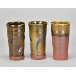 JOSHUA WILLIAMS; a set of three tall slipware beakers, impressed oak leaf marks, tallest 17.5cm (3).