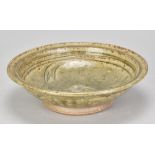 JIM MALONE (born 1946); a stoneware dish covered in green ash glaze with incised fish decoration,