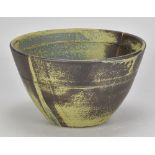 ROBIN WELCH (1936-2019); a stoneware bowl covered in green and mottled iron glaze with a streak of