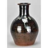 JIM MALONE (born 1946); a stoneware bottle covered in tenmoku breaking to kaki glaze with copper