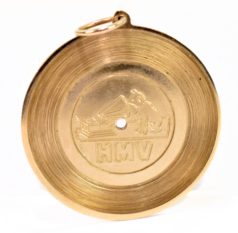 A novelty 9ct yellow gold pendant in the form of a record, inscribed to the centre 'HMV', and