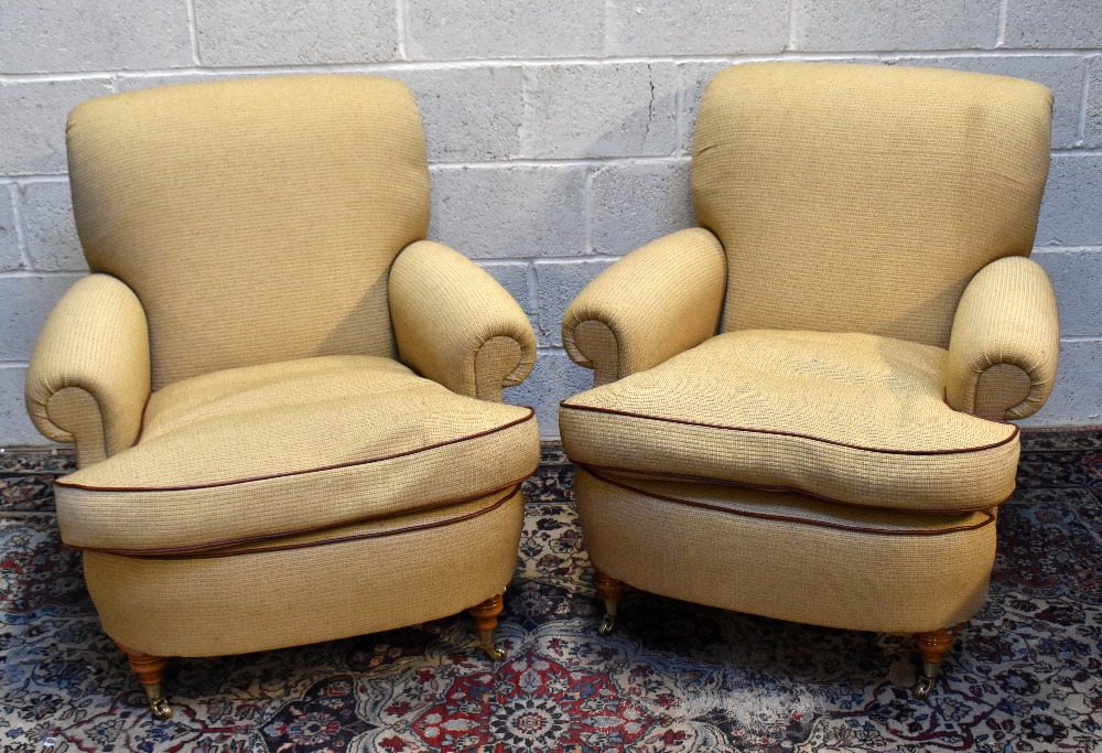 A pair of good quality reproduction armchairs on turned supports with brass castors.