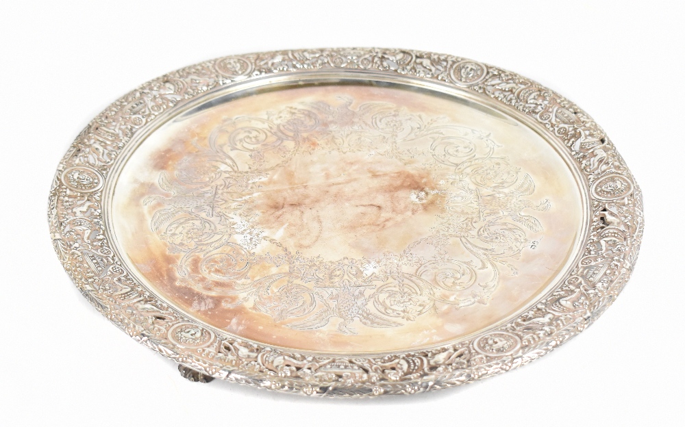 A 19th century white metal circular salver with engraved centre and pierced border, decorated with