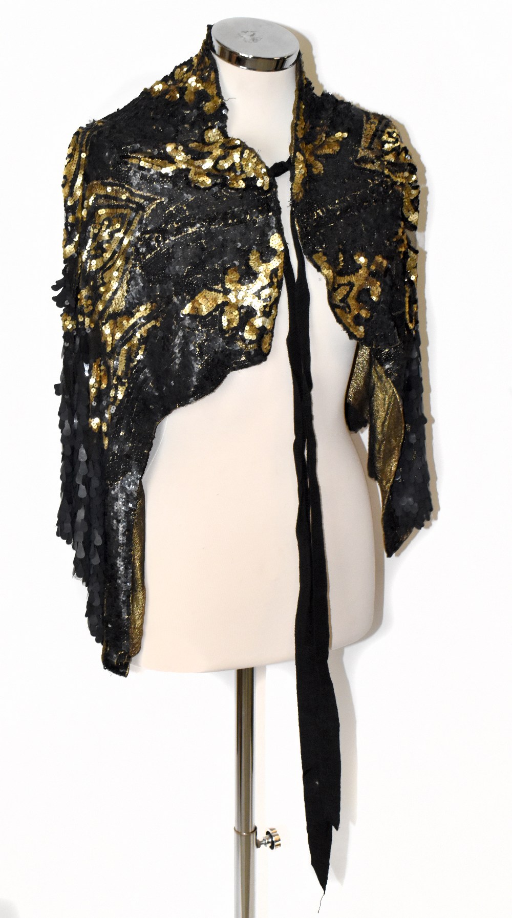 A 1930s gold metallic knit short shoulder cape covered in black lace embellished with large black
