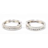 A pair of 18ct white gold hoop earrings, each channel set with nine brilliant cut diamonds to the