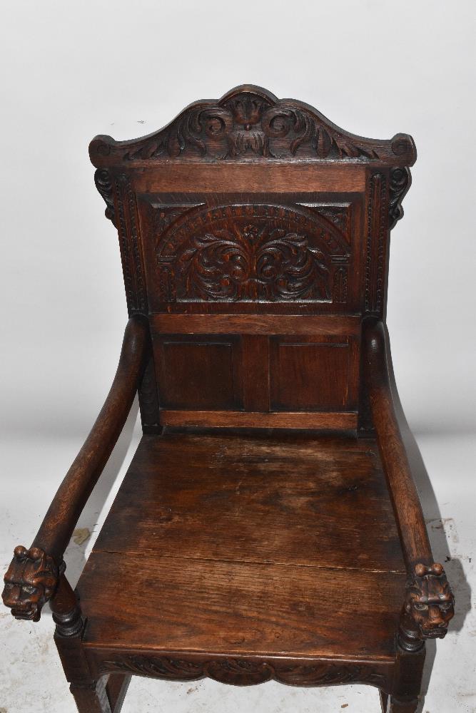 A Victorian carved oak open arm elbow chair with iron mask terminals and square supports. - Image 4 of 4