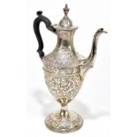 A George IV hallmarked silver coffee pot with urn finial and cast beaded rims, repoussé decorated