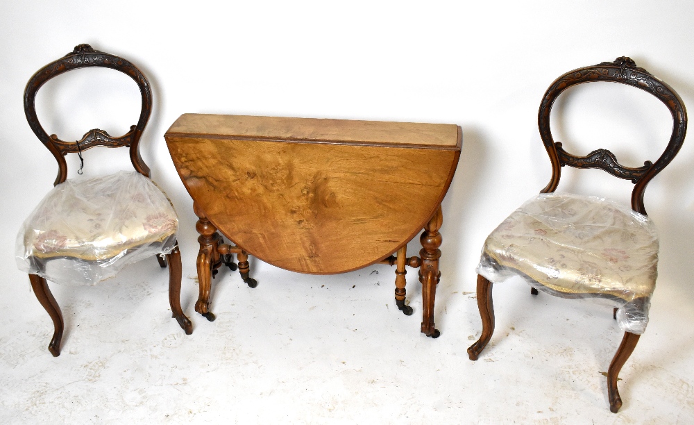 A pair of Victorian carved walnut framed balloon back bedroom chairs with floral upholstered