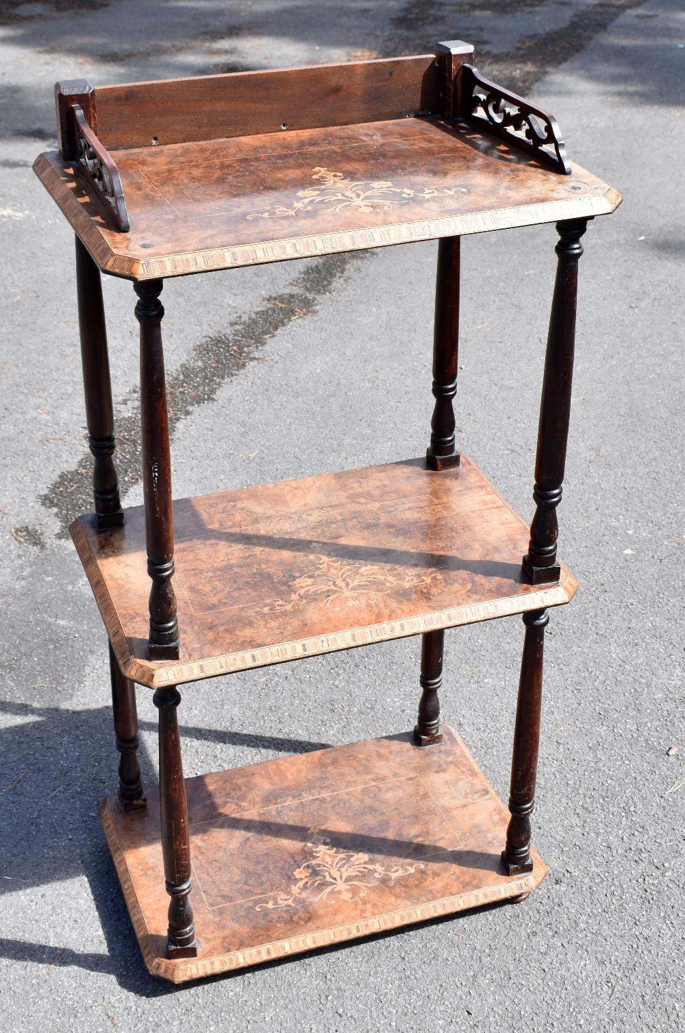 A Victorian walnut three tier whatnot, with galleried back and sides, and turned column supports,