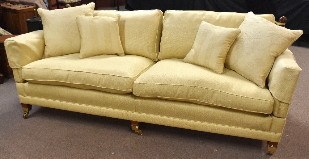 A pair of good quality reproduction Knowle sofas, on substantial square supports with brass castors.