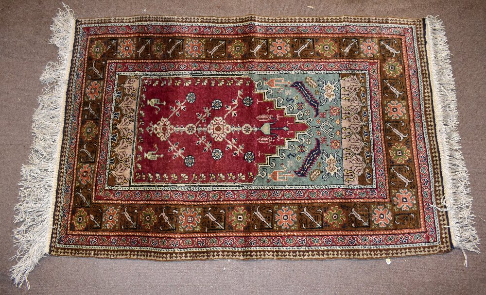 A Caucasian hand woven prayer rug, worked with all-over geometric motifs against a red ground, 140 x