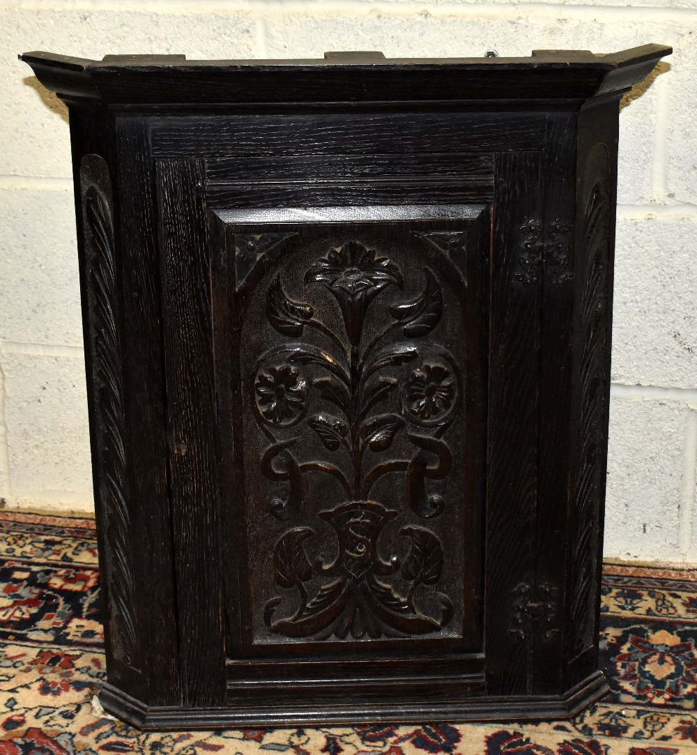An early 20th century carved oak wall hanging corner cupboard, height 75cm.