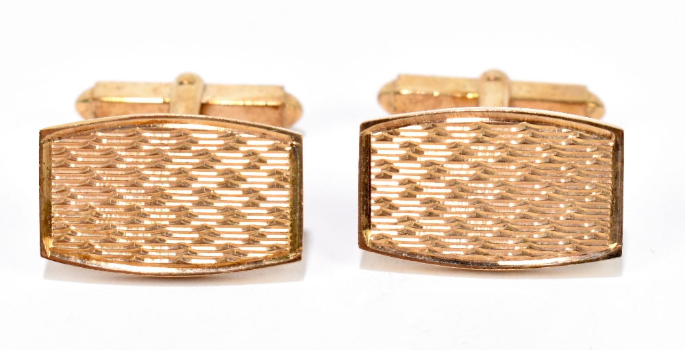 A pair of 9ct yellow gold cufflinks with engraved detail to the tonneau shaped platforms,