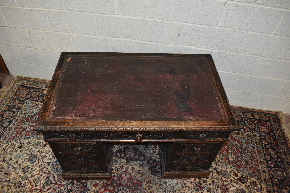 A Victorian carved oak nine drawer pedestal desk, 121.5 x 74cm.Additional InformationLeather top - Image 2 of 3