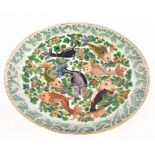 A late Meiji period Japanese porcelain charger, the central reserve decorated with Koi Carp on a