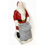 A vintage painted fibreglass charity collection box modelled as Santa Claus with his sack, height
