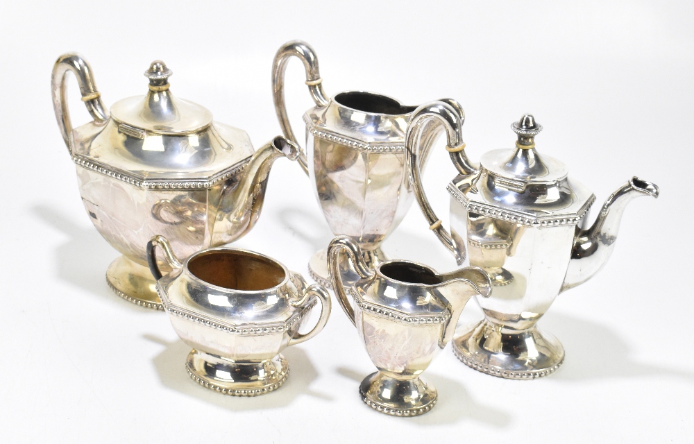 An unmarked white metal five piece tea service with panelled bodies and cast rims, with ivory