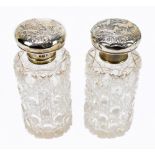 CARRINGTON & CO; a pair of Edwardian hallmarked silver mounted cut glass scent bottles and stoppers,