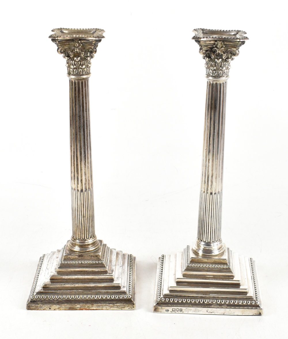 H.C. FREEMAN; a pair of late Victorian hallmarked silver Corinthian column candlesticks, with fluted