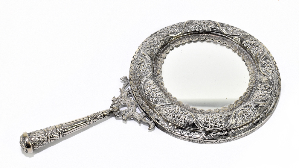 A Continental white metal dressing table mirror with embossed and cast decoration of grapevine