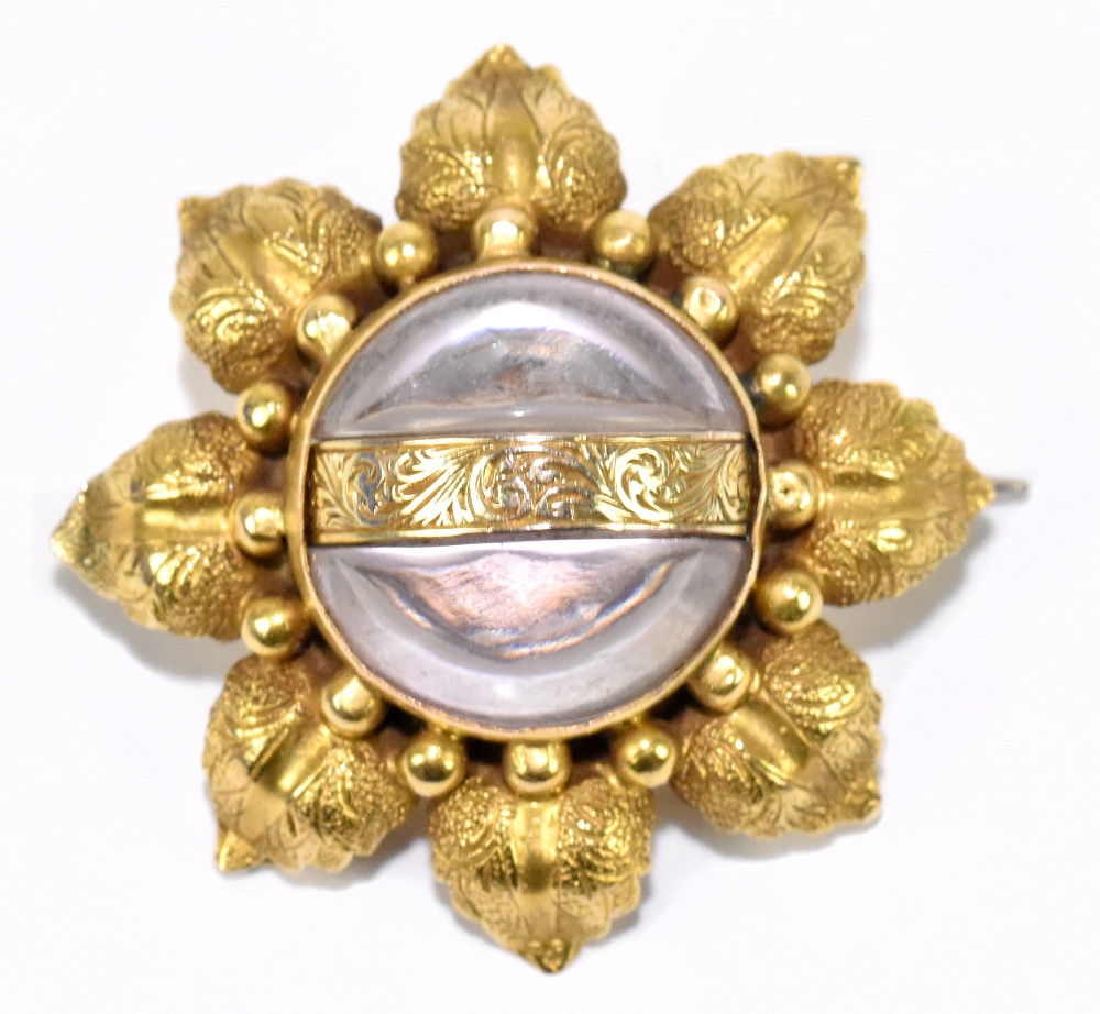 A yellow metal and pale amethyst flowerhead brooch formed of eight textured leaves and centred