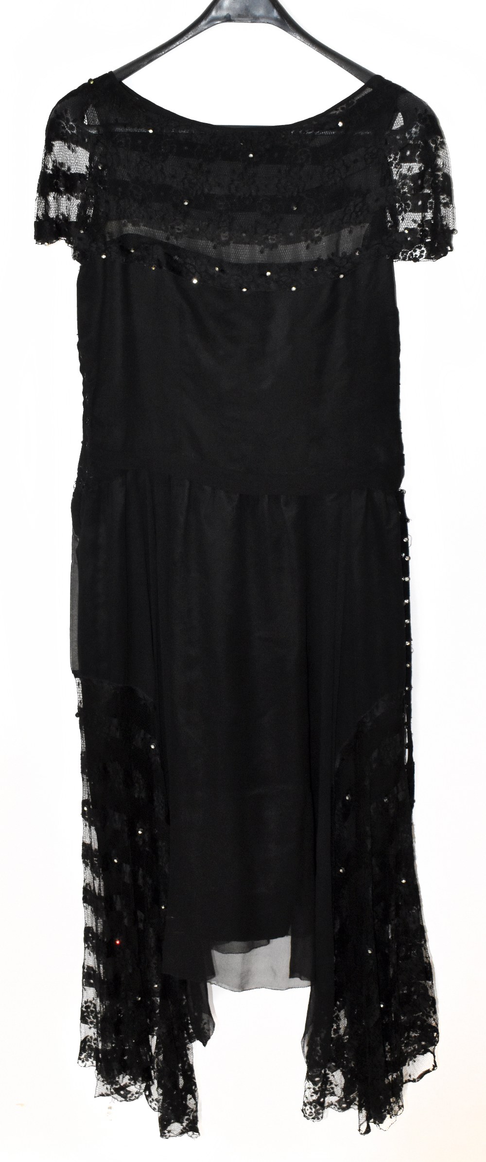 A 1920s black silk and handmade lace evening dress lined with silk with a swag hem embellished