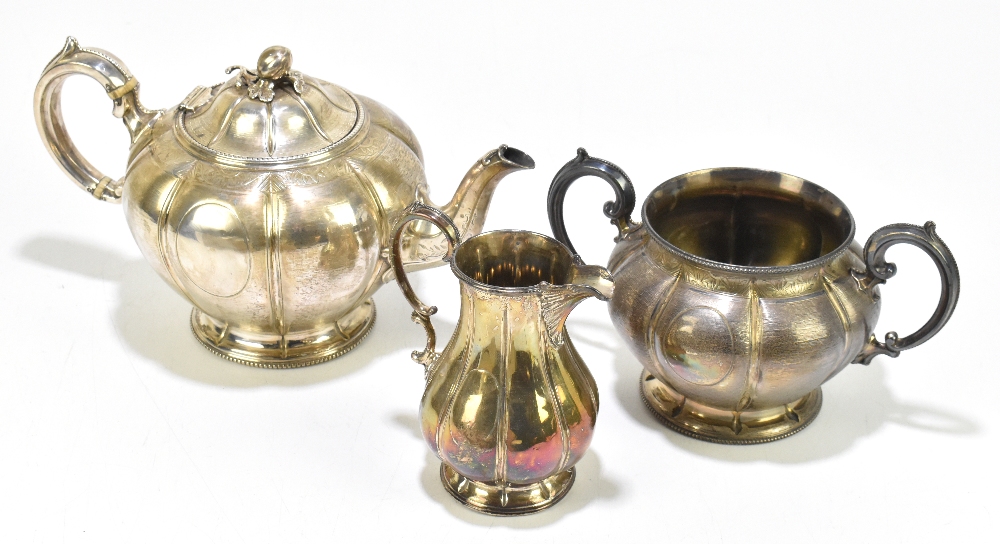 MARTIN, HALL & CO; a Victorian silver three piece tea service, the teapot with fruit and leaf