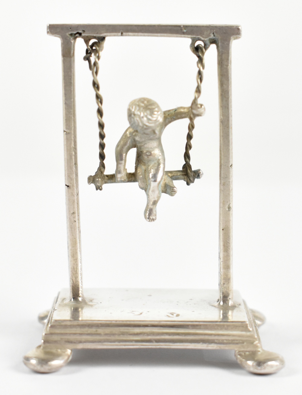 An early 20th century Dutch novelty silver model of a boy in a swing, weight 0.8ozt/25g, height 5.