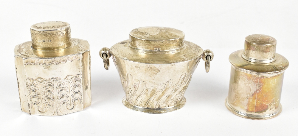 Three hallmarked silver tea caddies, comprising an Edwardian example with twin loop handles,