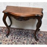 A reproduction mahogany serpentine front console table, with carved open shelf and scrolling