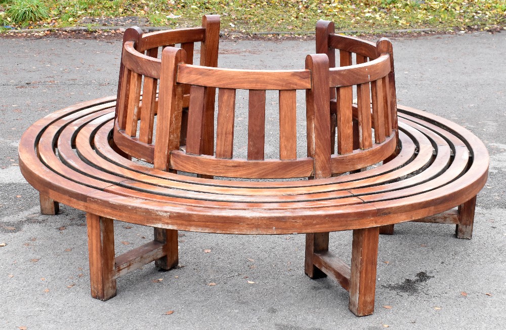 A teak semi-circular garden seat, made to fit around a tree.