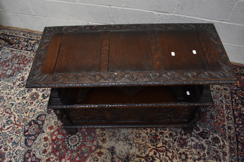 A 1920s carved oak monk's bench with carved and panelled back above the hinged seat, width 107cm, - Image 2 of 7