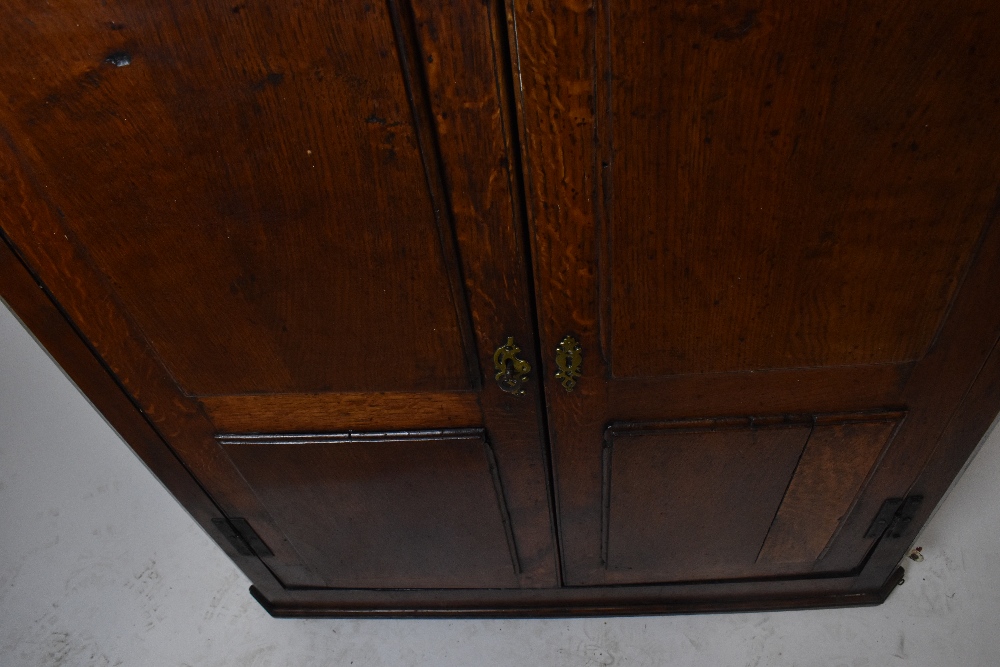 An 18th century oak hanging corner cupboard with iron H-hinges and a pair of panelled doors, width - Image 3 of 3