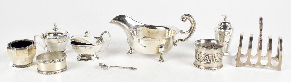 A hallmarked silver four piece cruet, Birmingham 1960, a Hugh Wallis Arts & Crafts silver napkin