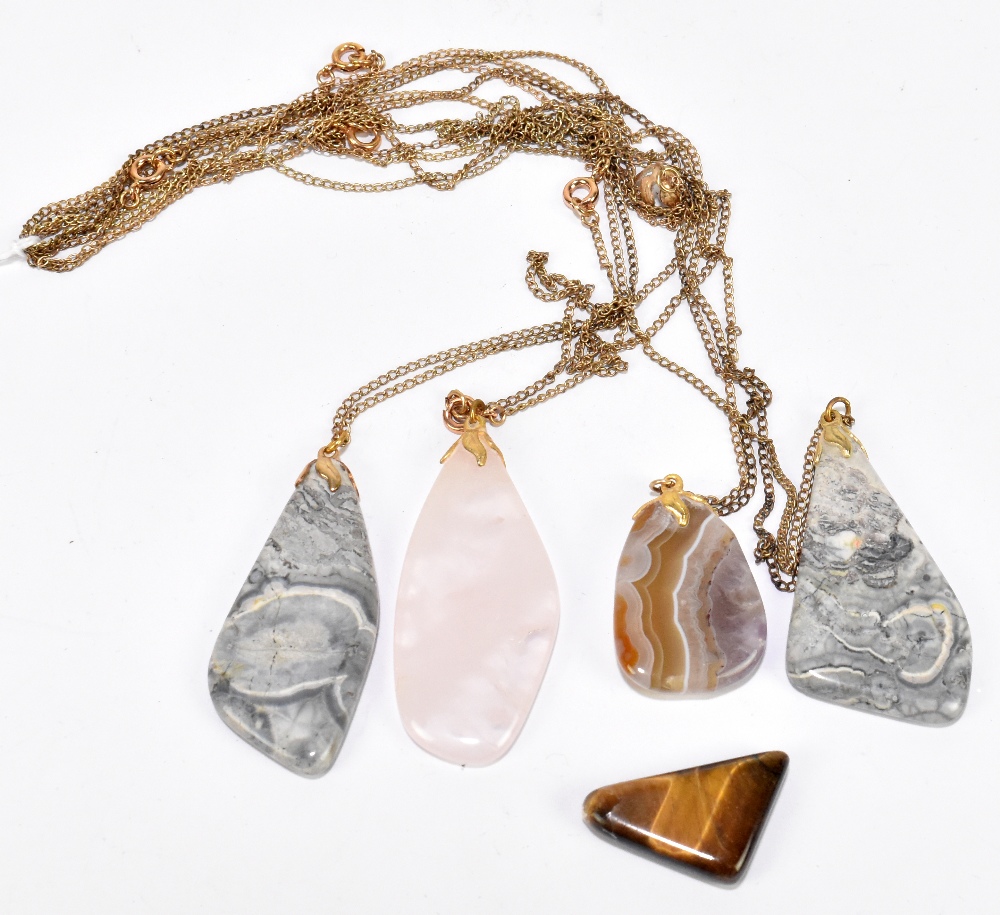 Five rolled gold chains, each suspending a polished hardstone abstract form pendant (5).