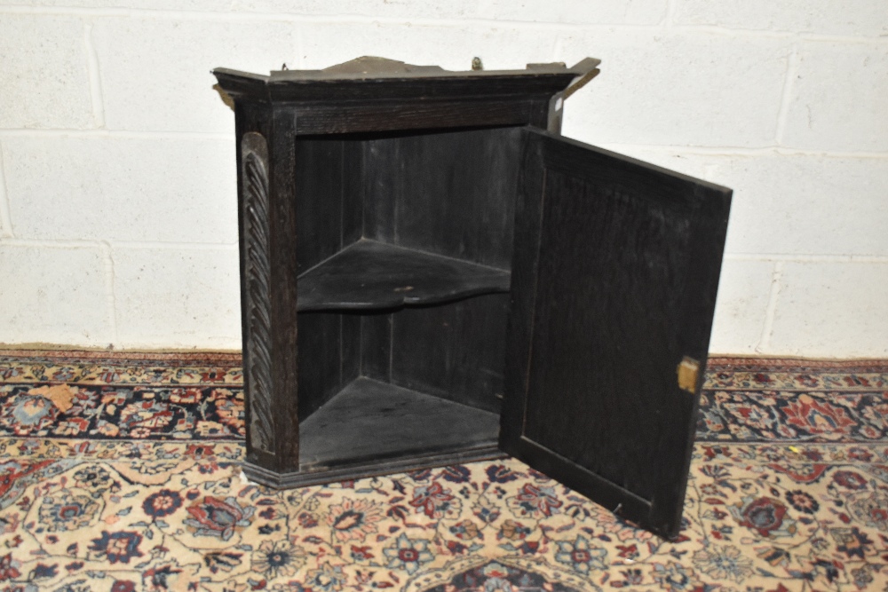 An early 20th century carved oak wall hanging corner cupboard, height 75cm. - Image 2 of 3
