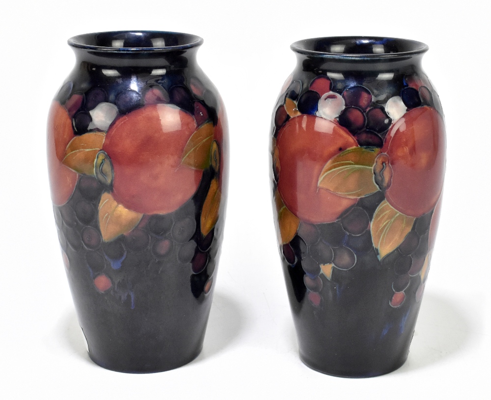 WALTER MOORCROFT; a pair of cylindrical vases with flared necks decorated in the 'Pomegranate'