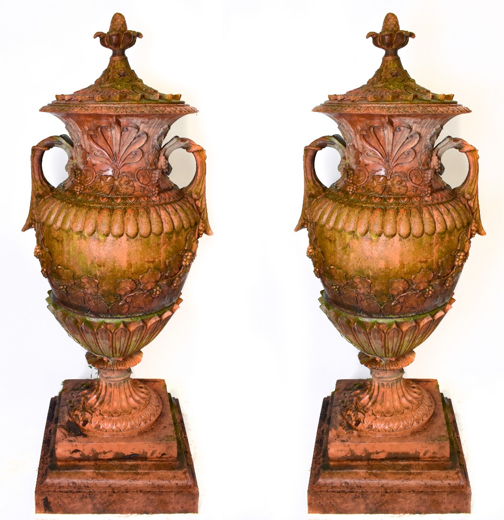 A pair of large ornate terracotta twin handled lidded urns, height 153cm.